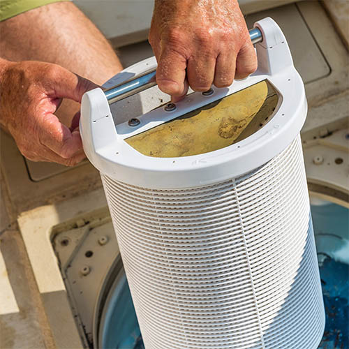 Pool skimmer basket being cleaned